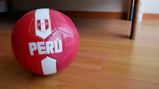 Close-up of customized size 5 soccer balls with Ecuadorian colors on a wooden floor