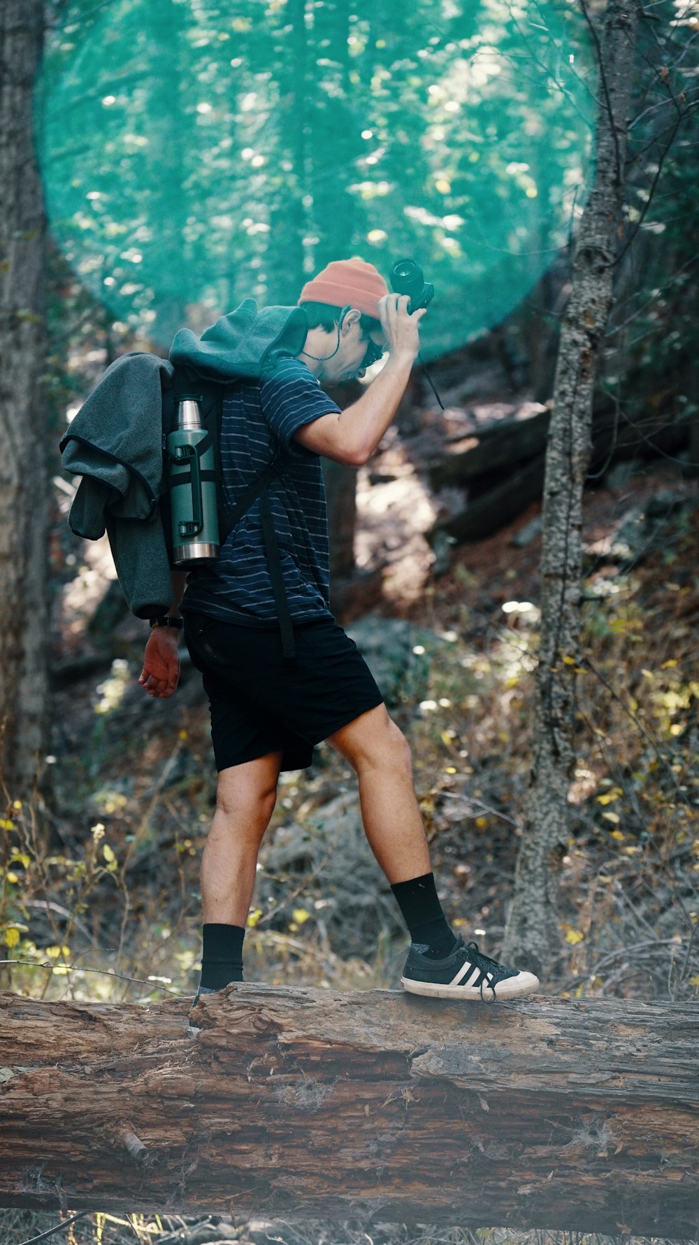 man walking on dirt road holding DSLR camera during daytime