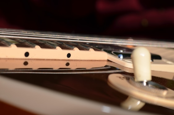 Close-up of a handcrafted steel guitar part resting on a sleek urban wooden table with city skyline blurred in the background.