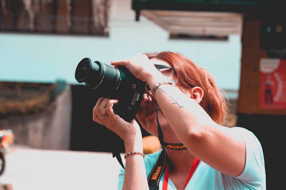 woman using black Nikon DSLR camera