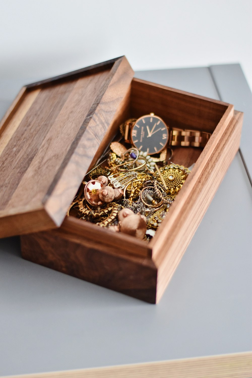 gold watch and pendant on brown wooden box
