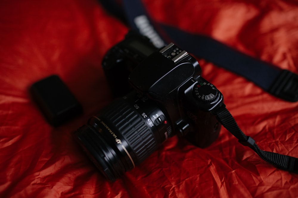 black DSLR camera on red textile