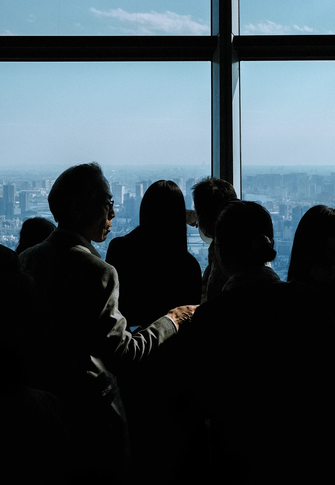 Guests gathered by a window overlooking the city