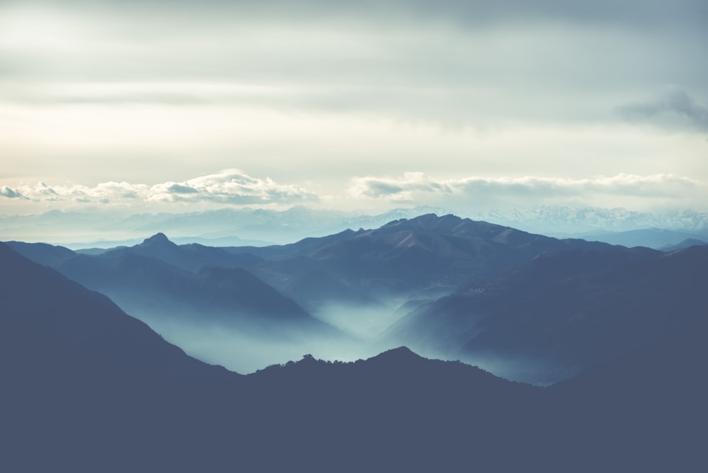 black rocky mountain under white cloudy sky