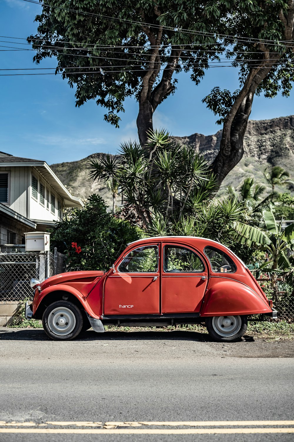 classic red car parked on roadside during daytime