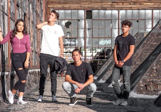 Young people wearing streetwear posing in an industrial urban setting.