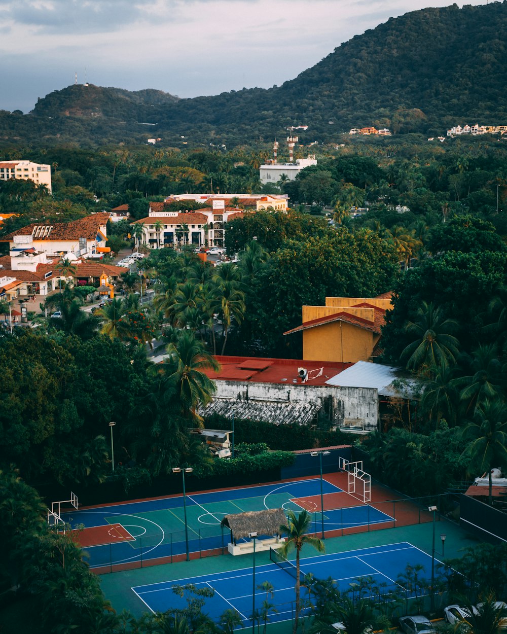 aerial photography of double purpose basketball and tennis court during daytime