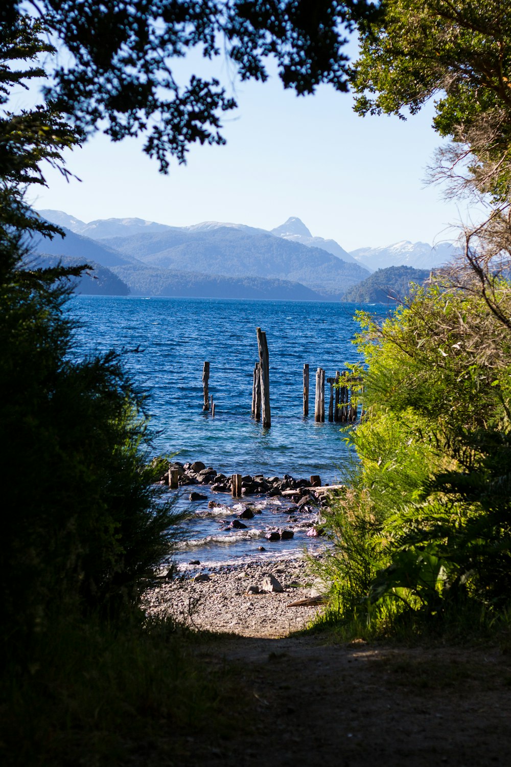 calm sea with mist mountain during daytime