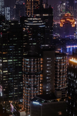 Nighttime 3D visualization of an illuminated urban complex highlighting vibrant lighting design.