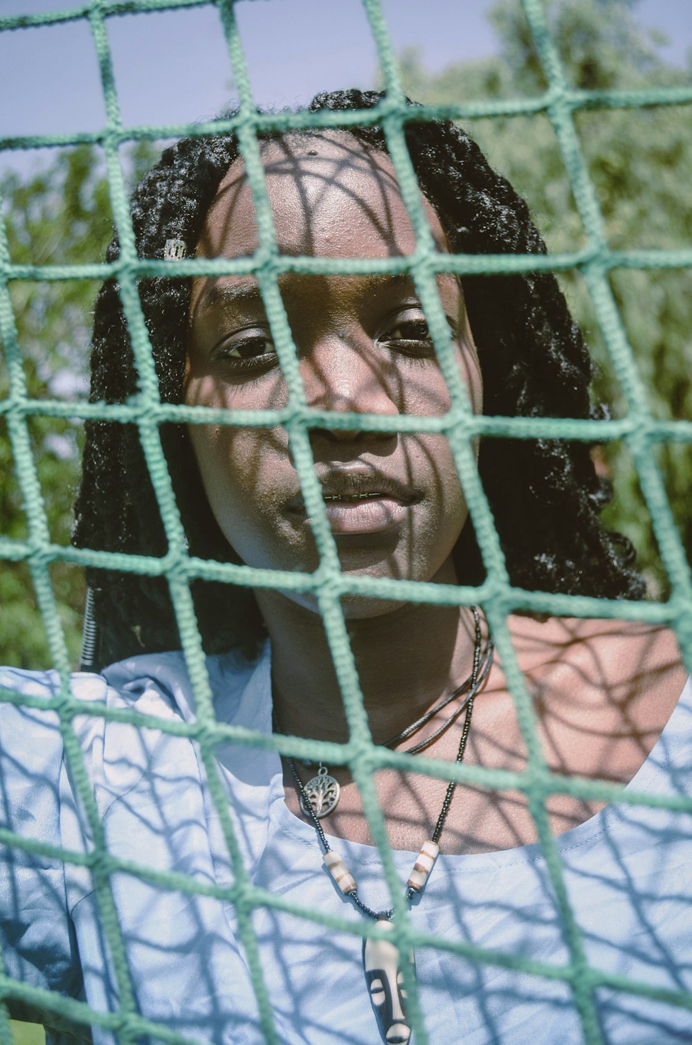 woman in blue scoop neck shirt through net