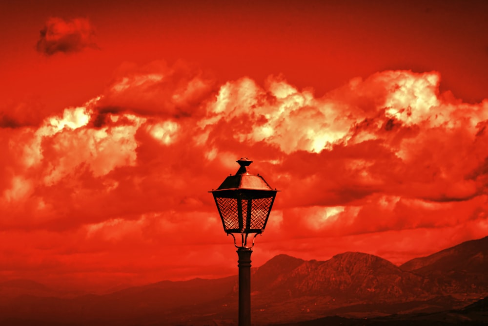 black street lamp under cloudy sky during daytime