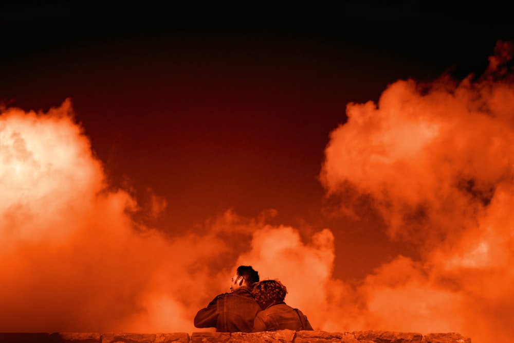 man and woman sitting on bench