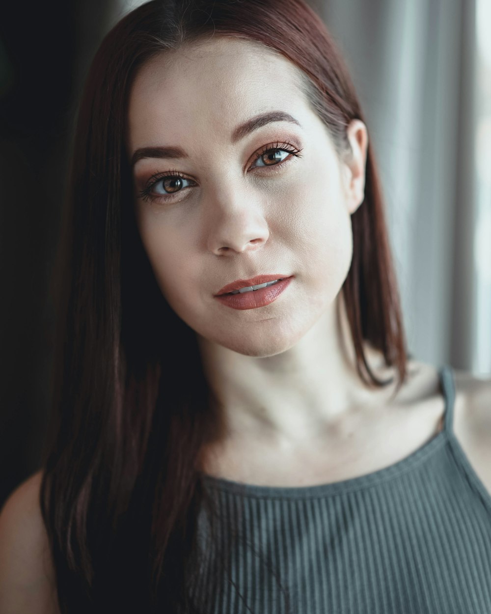 woman in gray cami top smiling