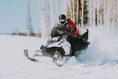 A provider navigating a snowmobile across frozen tundra to reach a remote village.
