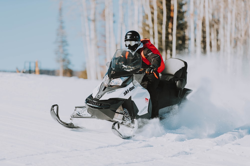 snowmobile speeding on snow near tree lines