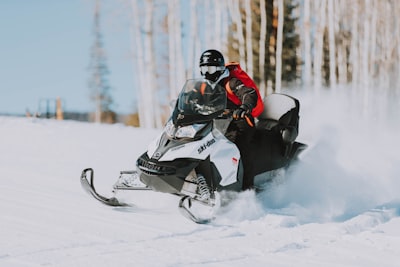 snowmobile speeding on snow near tree lines sled zoom background