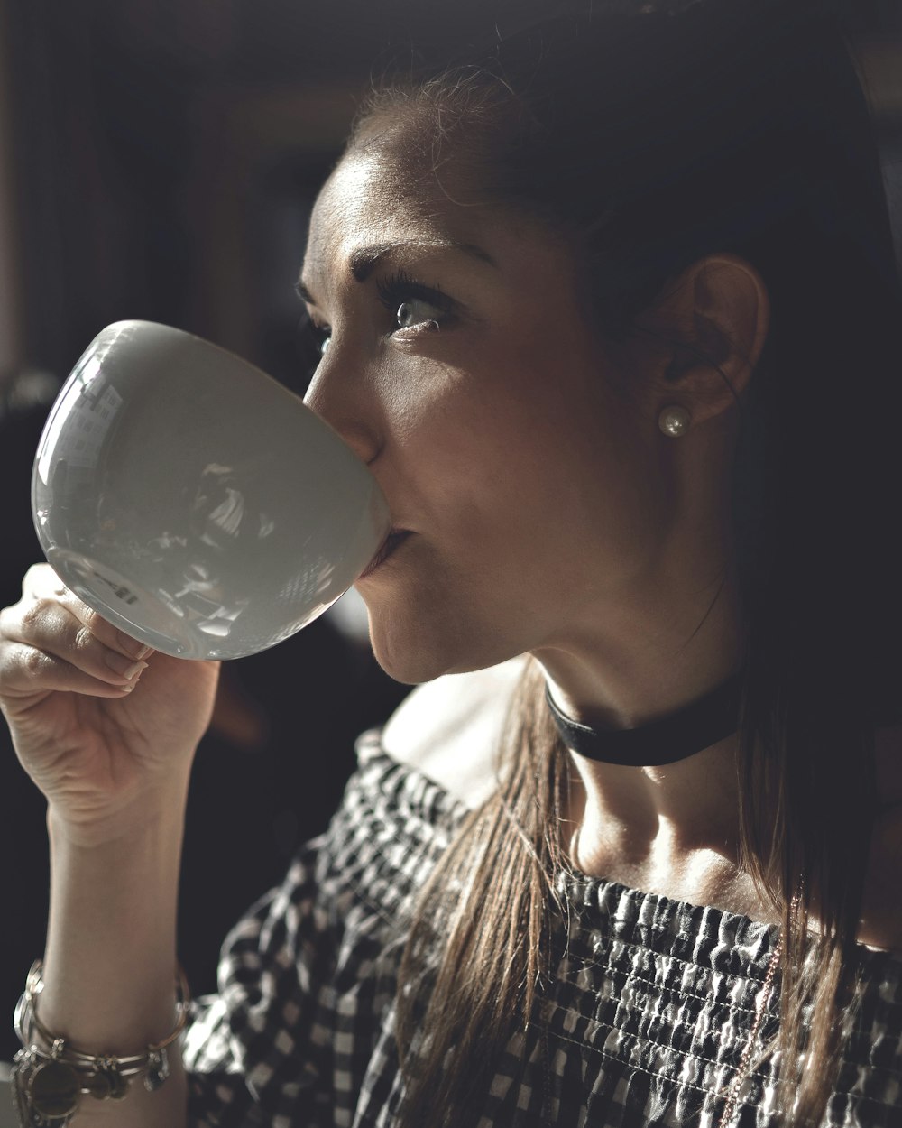 woman holding white teacip