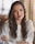 woman in white sweater crossing hands while smiling