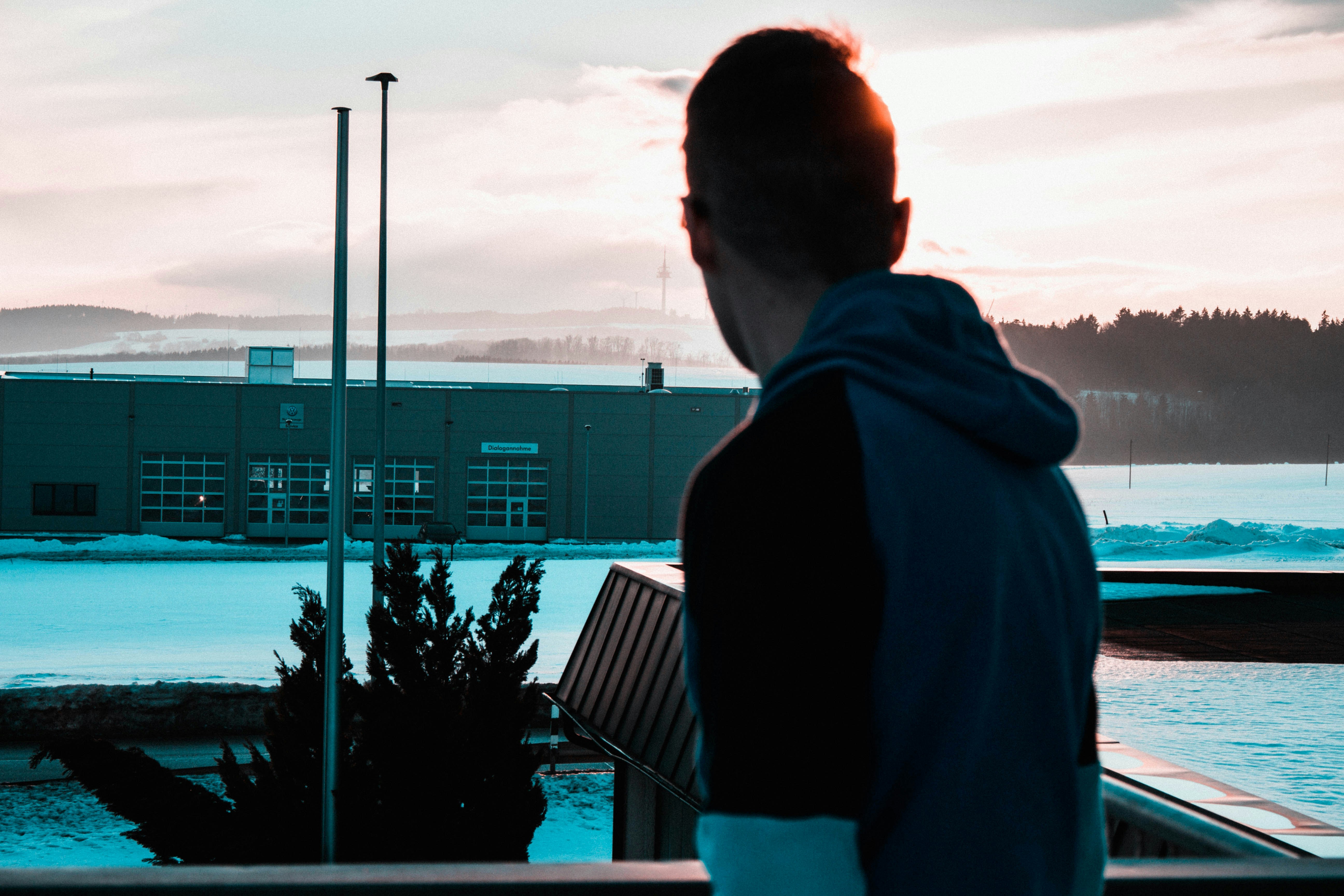 man wearing black-and-blue pullover hoodie during daytime