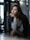 woman in grey long sleeved shirt with blue jacket with cross leg while putting left hand on chin