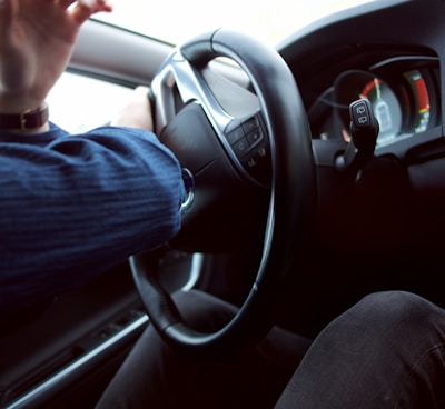 man holding black steering wheel