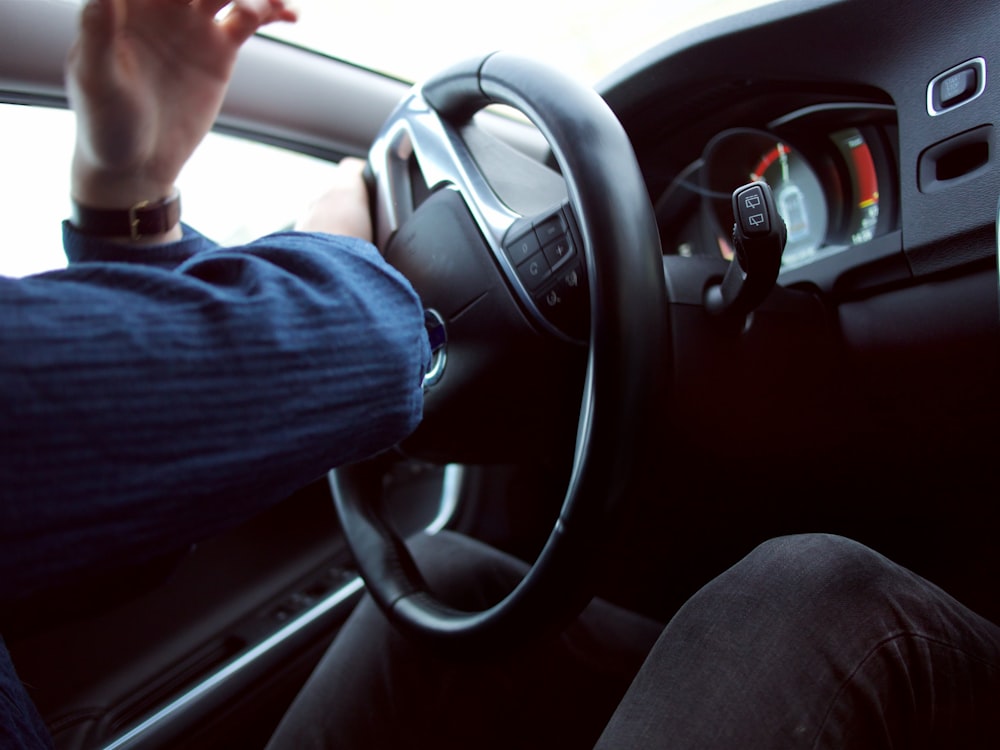 homem segurando o volante preto