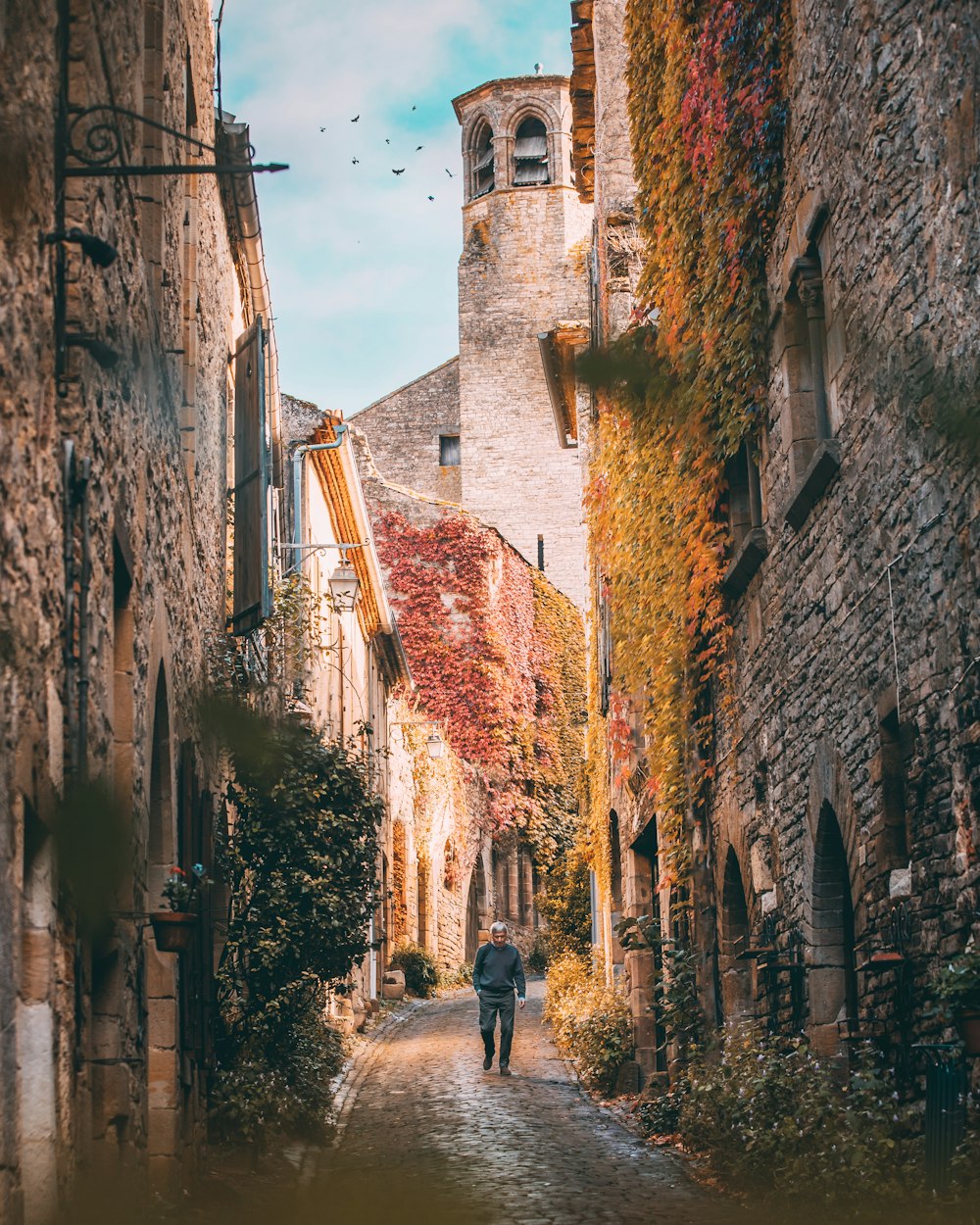 man walking at alley between concrete buildings during daytime