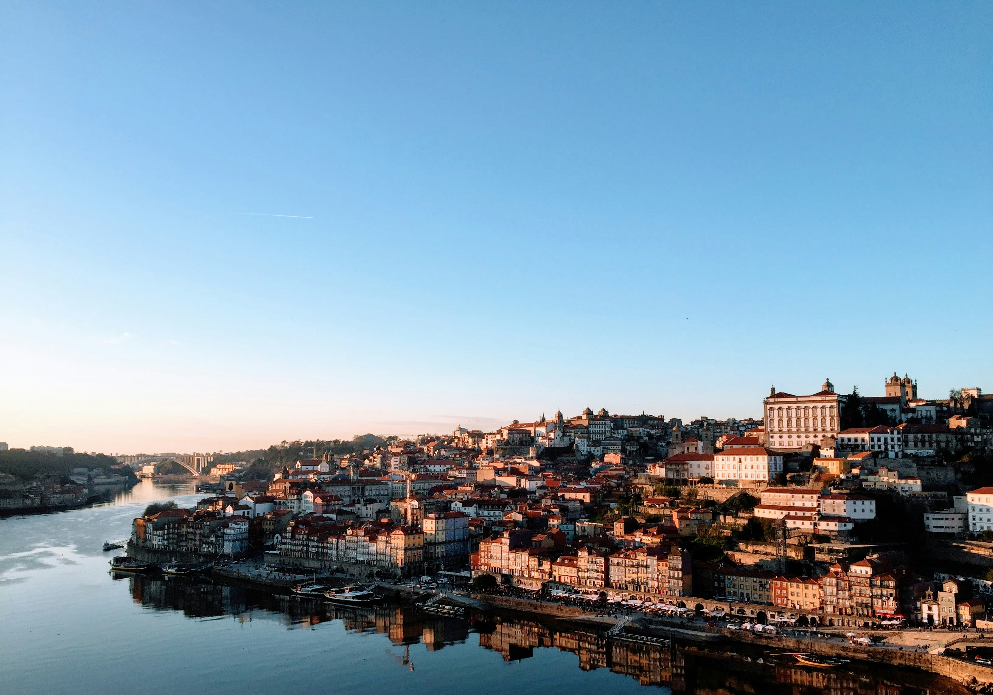 city houses and buildings near river under blue sky