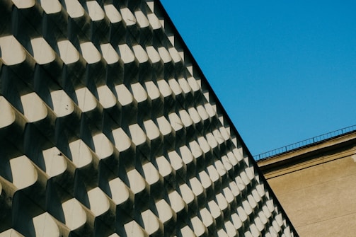 Architectural blueprint overlaying a modern building facade under natural light.