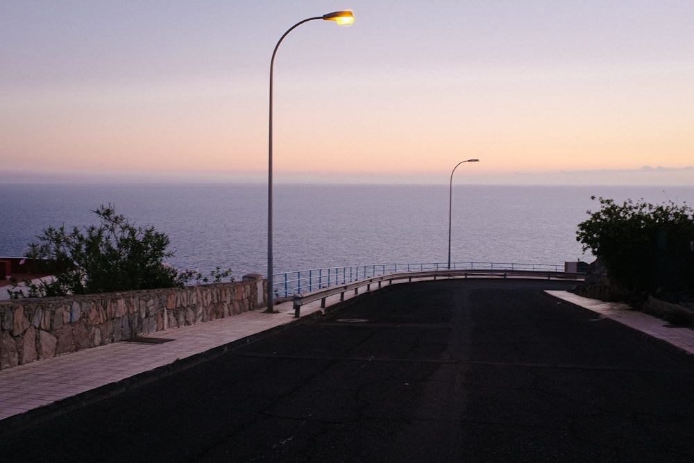 black road near body of water