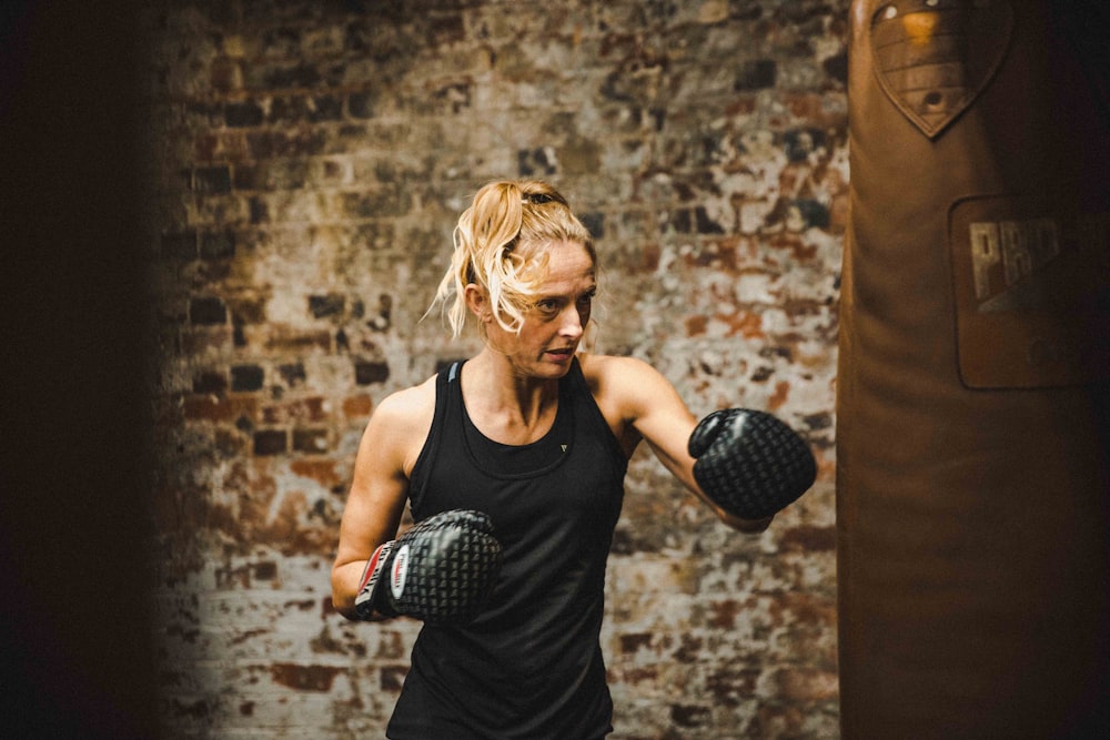 woman in black tank top wearing boxing gloves