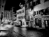 Black and white photograph of an old street with cobblestones and vintage lamps