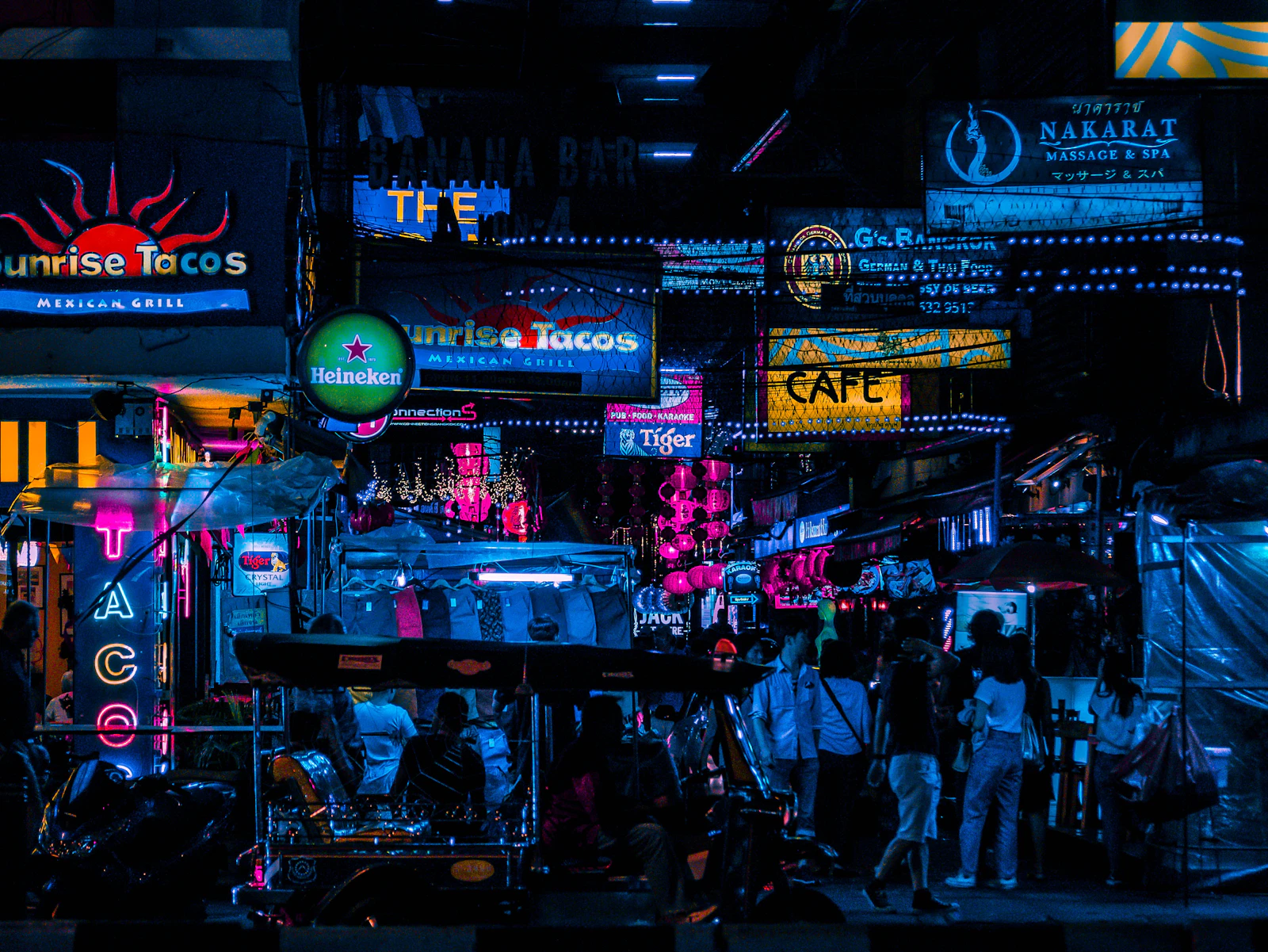 People walking through a Bangkok night market.