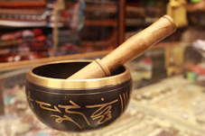 Close-up of a softly glowing Tibetan singing bowl resting on a natural linen cloth.