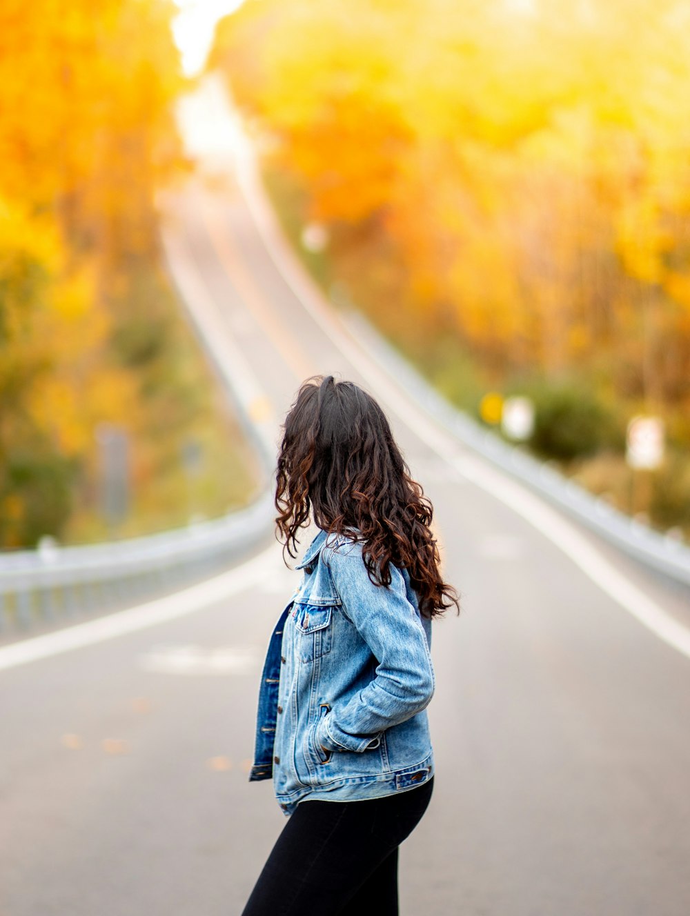 woman standing on road while hand in pocket during daytime