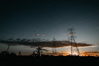low-angle photography of transmission towers during golden hour