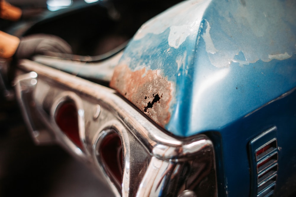 closeup photography of classic blue car with rusted panels