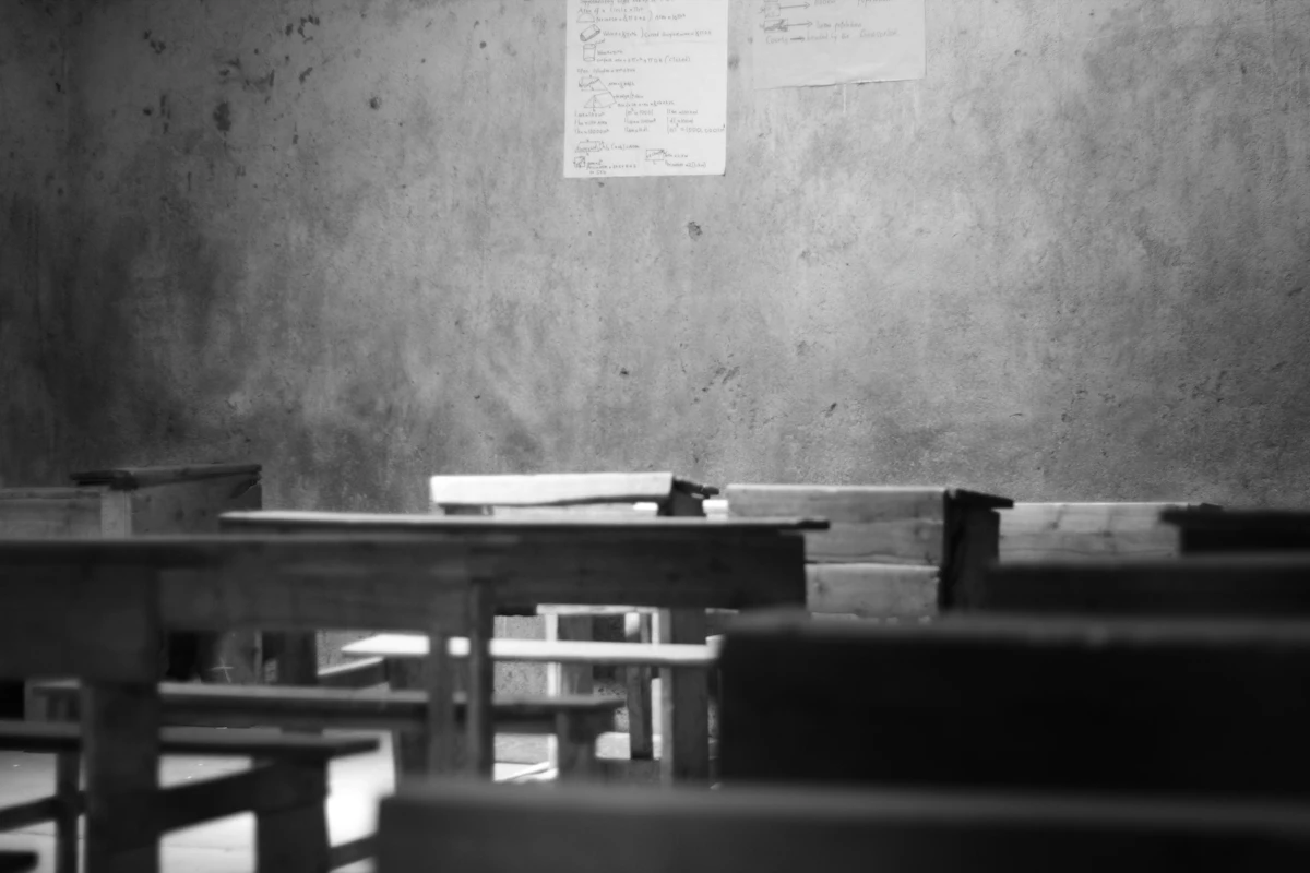 Grayscale photography of school desk and board