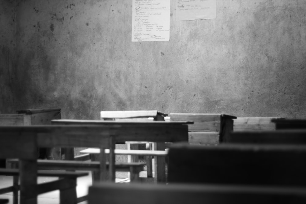 grayscale photography of school desk and board