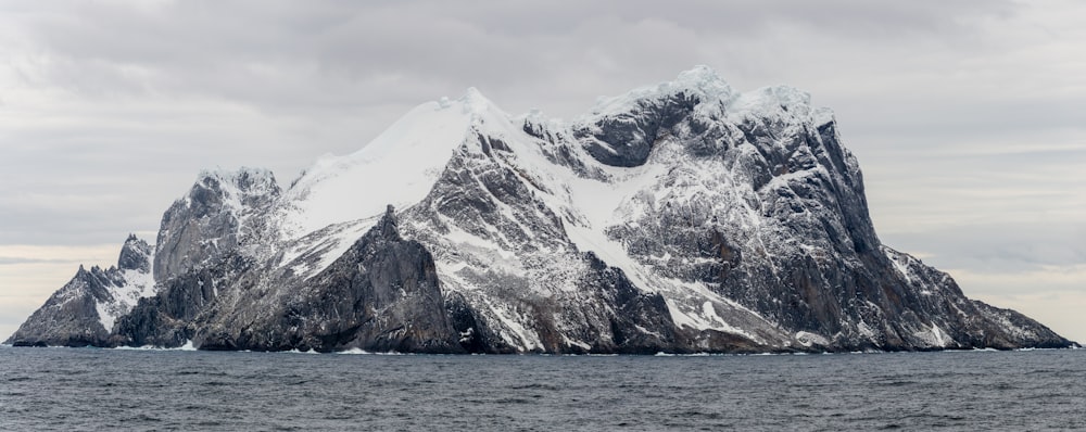 snow capped mountain surrounded by body of water