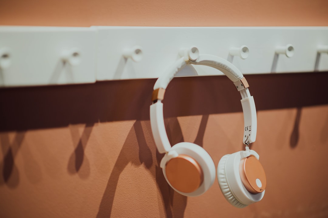 white and brown headphones hanging from hook