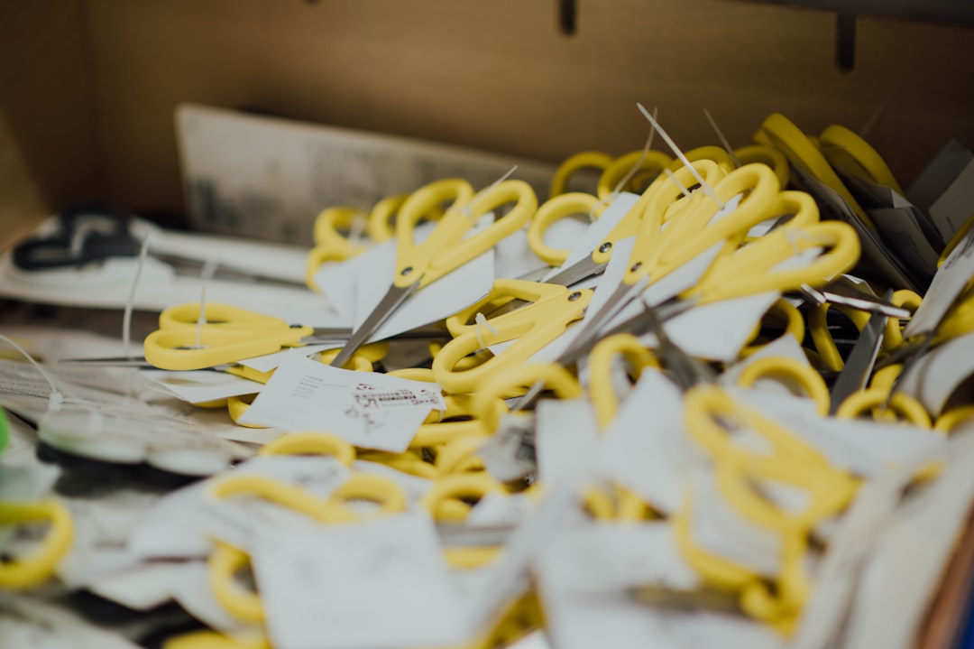 yellow scissors on brown wooden surface