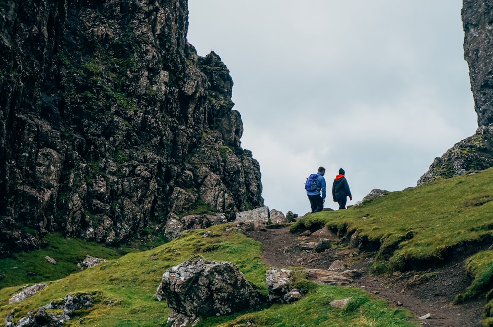 homme et femme marchant sur la montagne pendant la journée