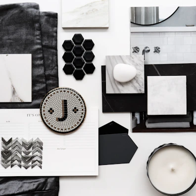 Artful flat lay of branding materials in black, off-white, and warm gray tones.