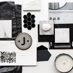 Artistic composition of design sketches and material samples on a neutral-toned surface.