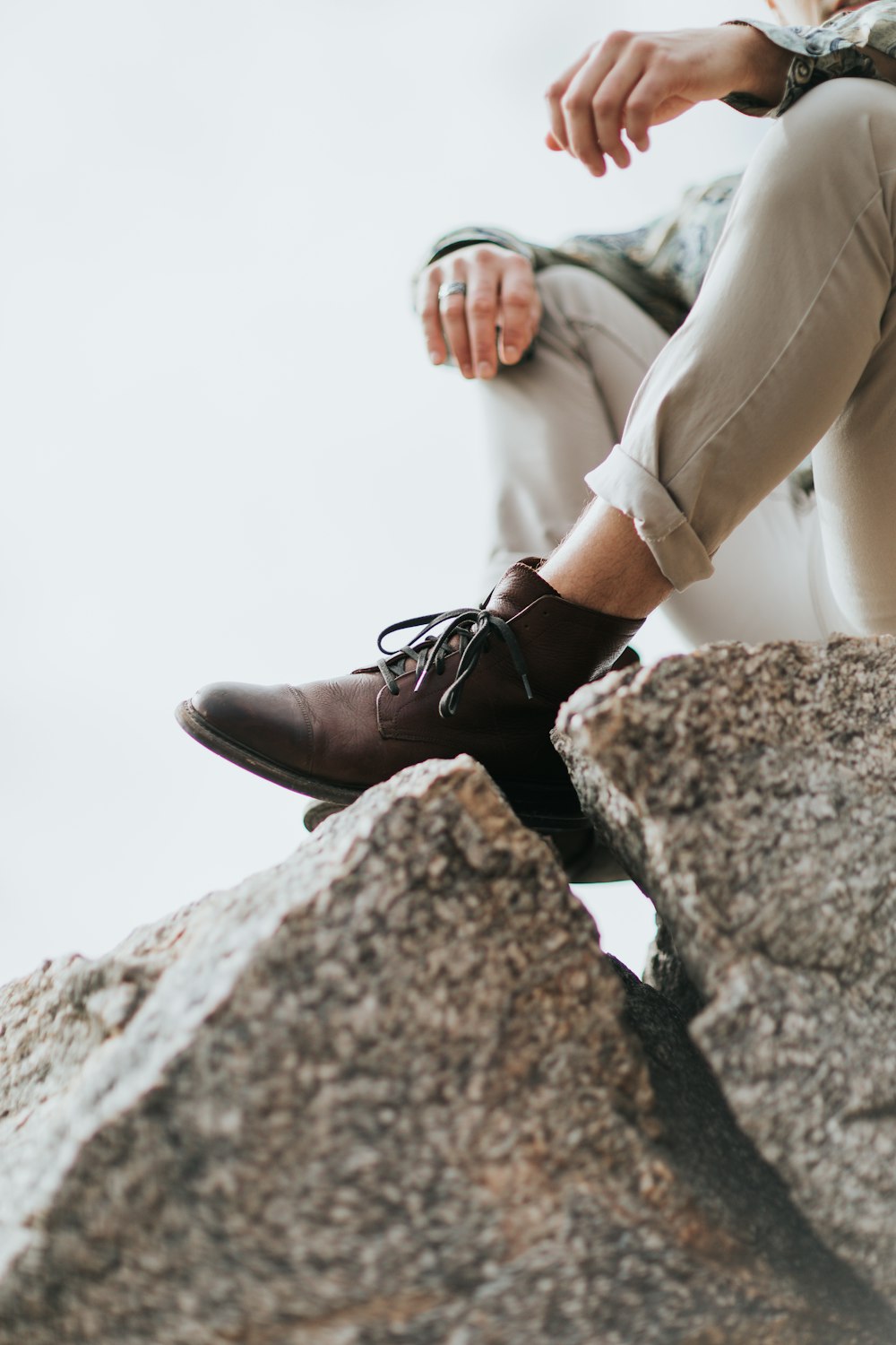 man sitting on gray rock formation