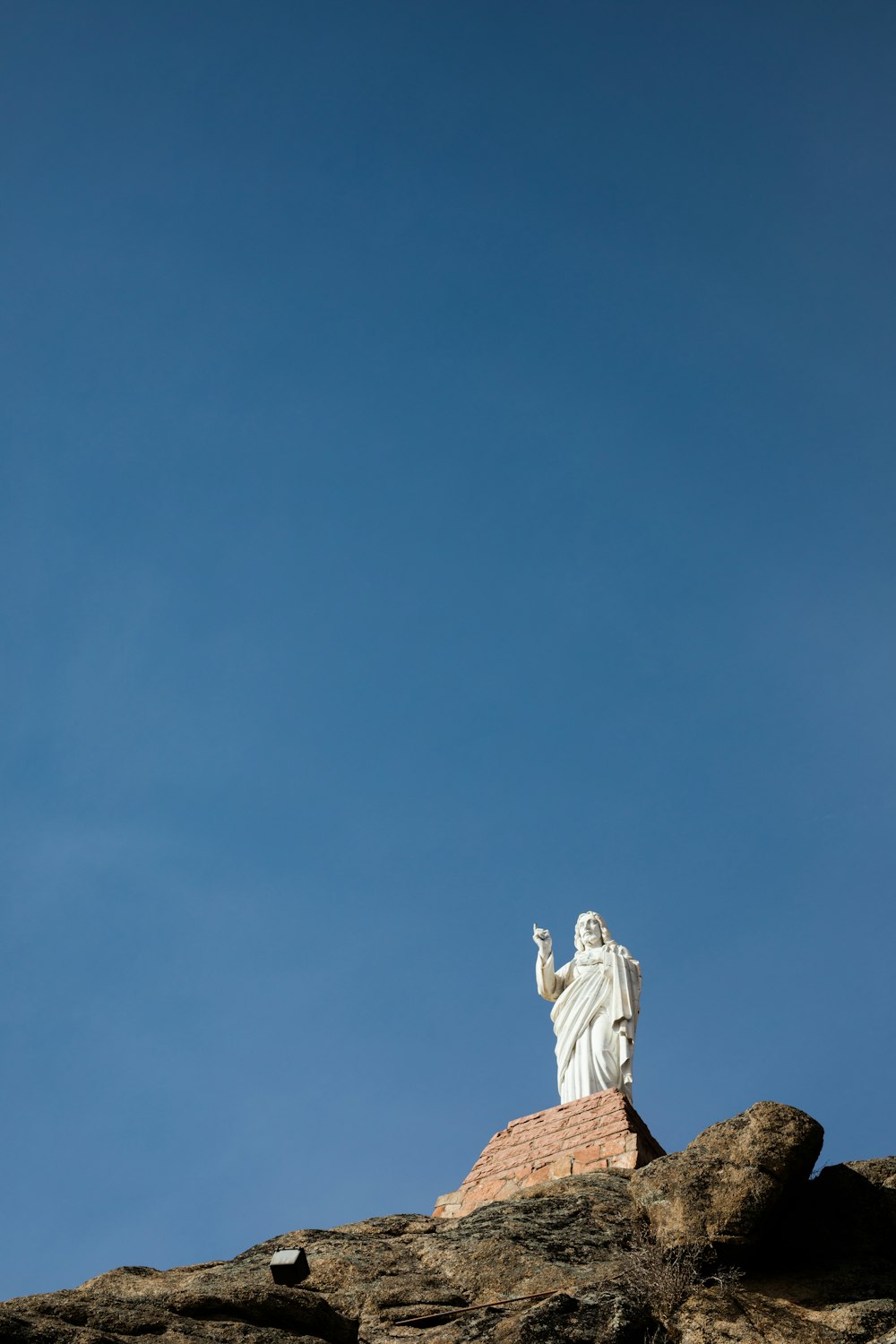 low-angle photography of Jesus Christ statue under clear blue sky