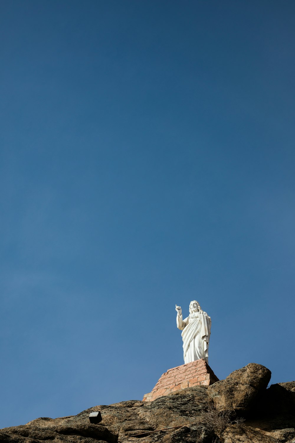 fotografía de ángulo bajo de la estatua de Jesucristo bajo un cielo azul claro