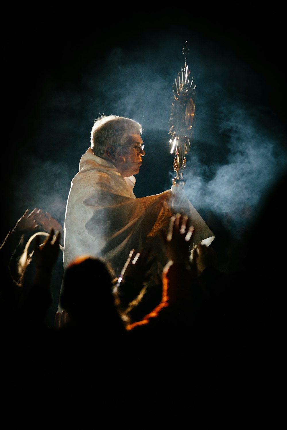 man holding stick wearing white robe
