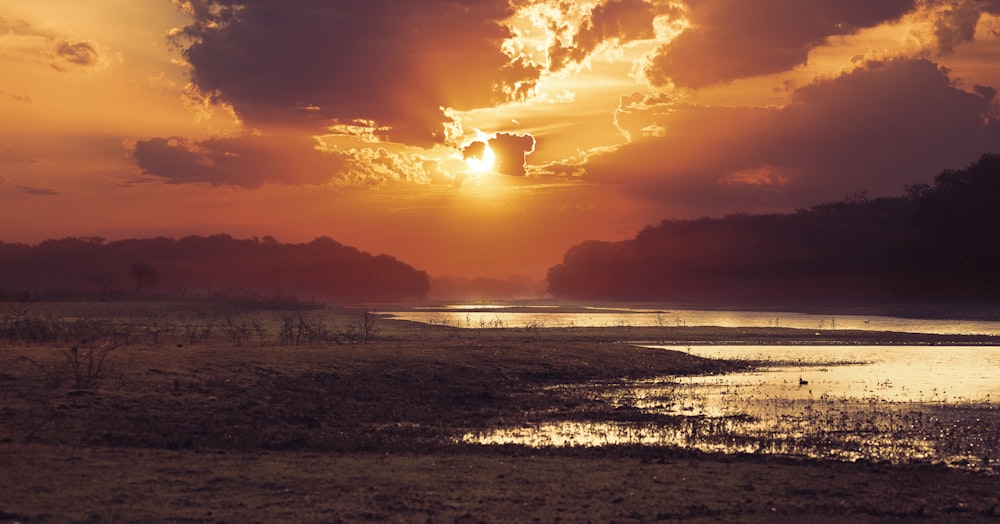 Leere Felder in der Nähe eines Gewässers während des Sonnenuntergangs